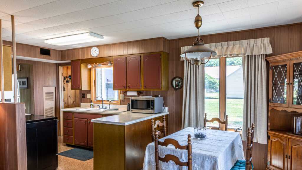 A kitchen with wooden cabinets and white table