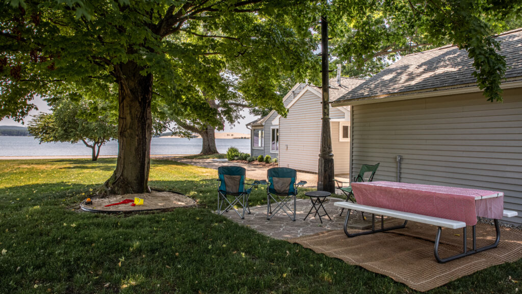 A backyard with lawn chairs and a table.