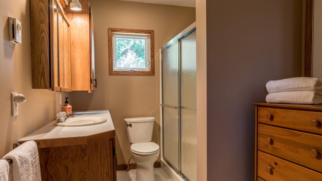 A bathroom with a toilet, sink and shower.