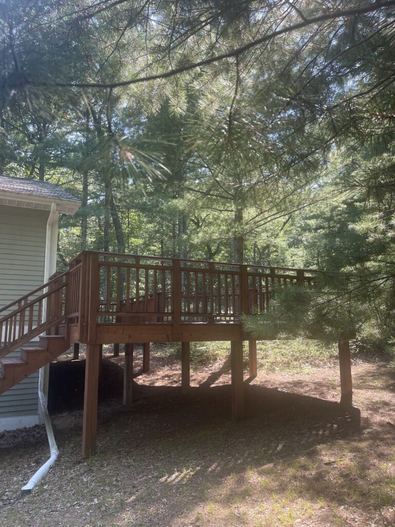 A wooden deck with stairs leading to the back of it.