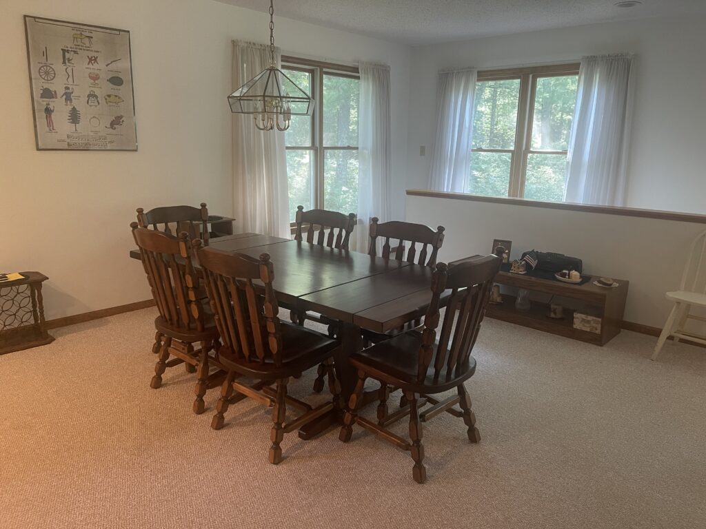 A dining room table with six chairs in it.