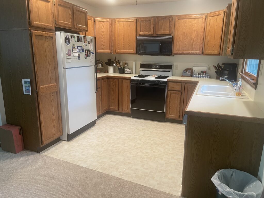 A kitchen with wooden cabinets and white appliances.