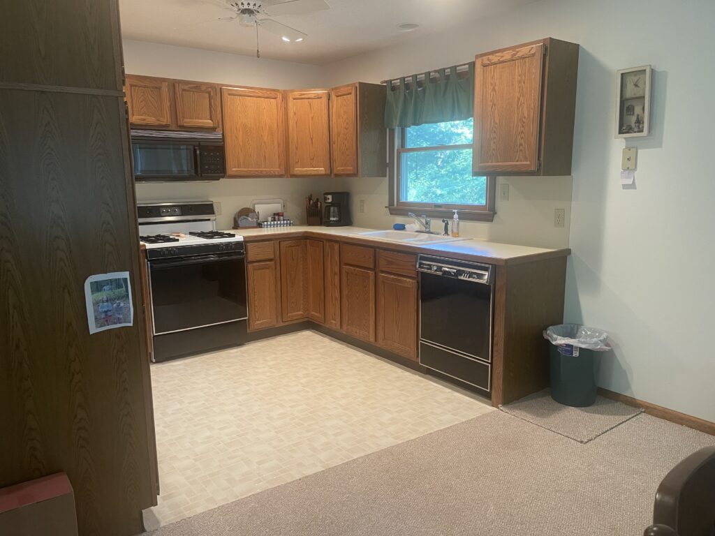 A kitchen with wooden cabinets and white appliances.