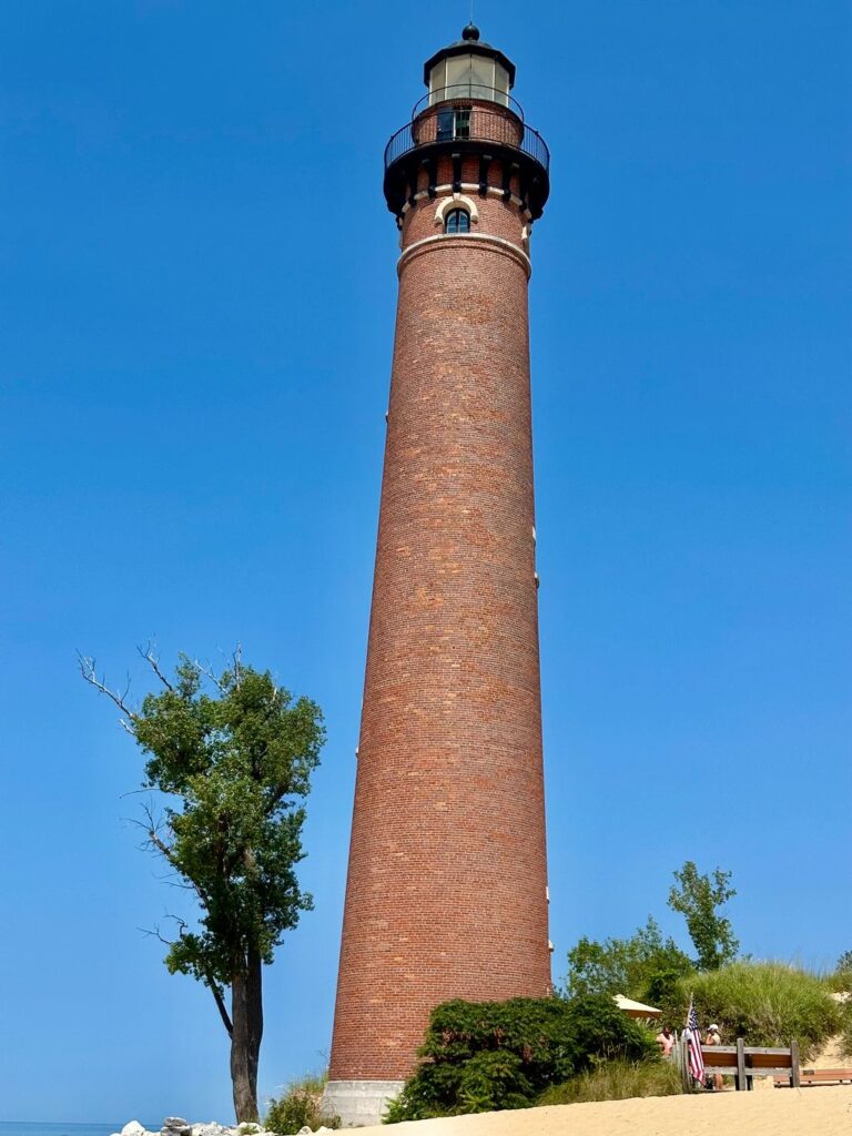 A tall brick tower with a clock on it's side.