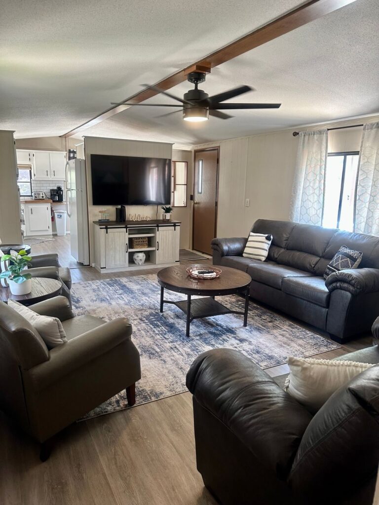 A living room with couches, chairs and a television.